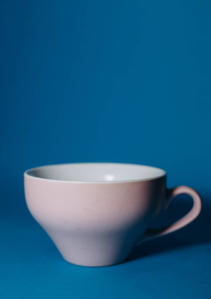 pink cup on a blue background - Foto, Imagen
