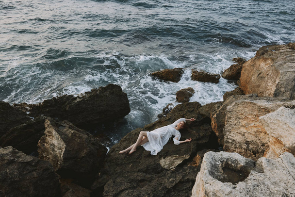 nő feküdt sziklás parton repedések sziklás felszíni kilátás felülről. Kiváló minőségű fénykép - Fotó, kép