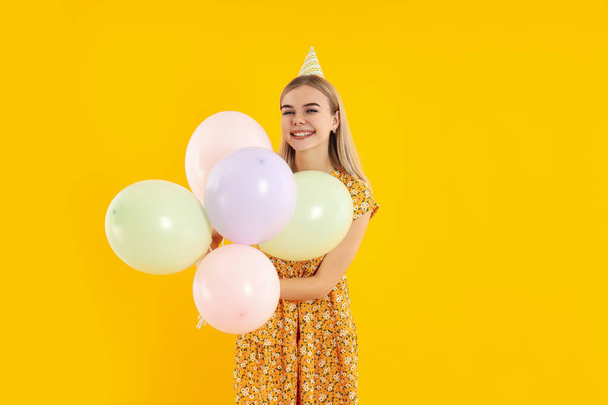 Concept of Happy Birthday με ελκυστικό κορίτσι σε κίτρινο φόντο - Φωτογραφία, εικόνα