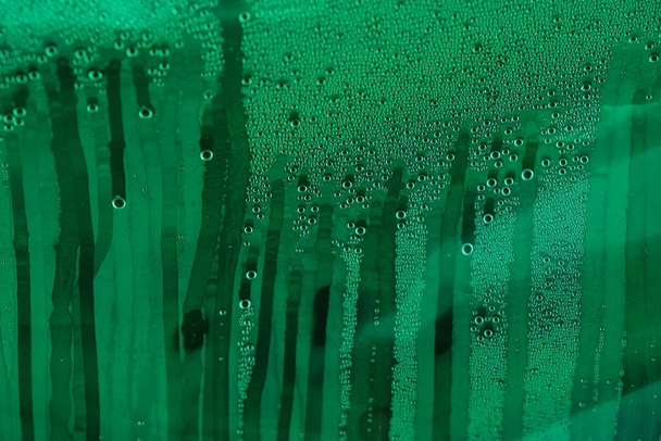 Το νερό τρέχει κάτω. Συμπύκνωμα νερού. Πράσινο χρώμα. Περίληψη. Αντιγραφή χώρου. Επιλεκτική εστίαση. - Φωτογραφία, εικόνα