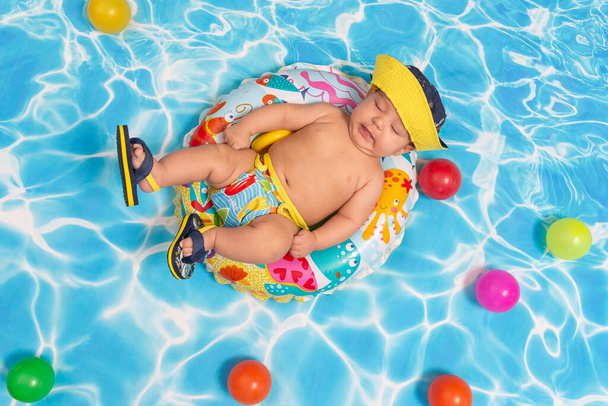 Baby enjoying in a swimming pool. Studio portrait. - Photo, image