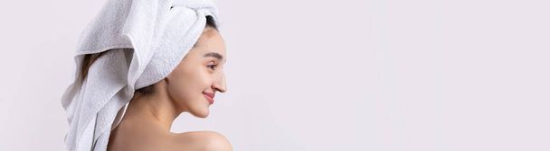 Beautiful girl with thick eyebrows and perfect skin at white background, towel on head, beauty photo. - Foto, Bild