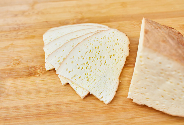 σπιτικό καπνιστό τυρί κομμένο σε ξύλινη σανίδα - Φωτογραφία, εικόνα
