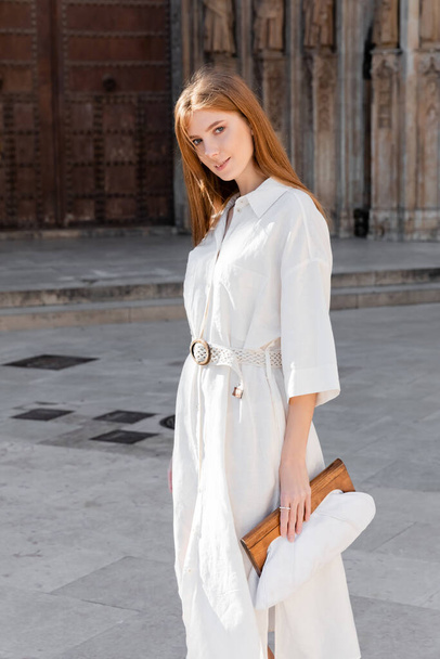 young redhead woman in dress holding purse on street of valencia  - Fotoğraf, Görsel