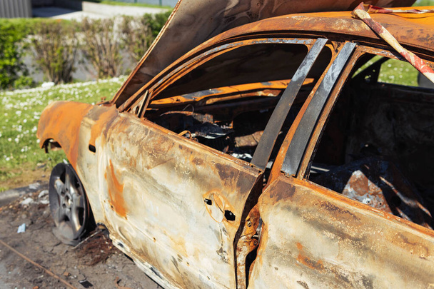 Coche quemado con estado quemado en aislamiento en el lado de la carretera en la naturaleza. Foto de alta calidad - Foto, Imagen