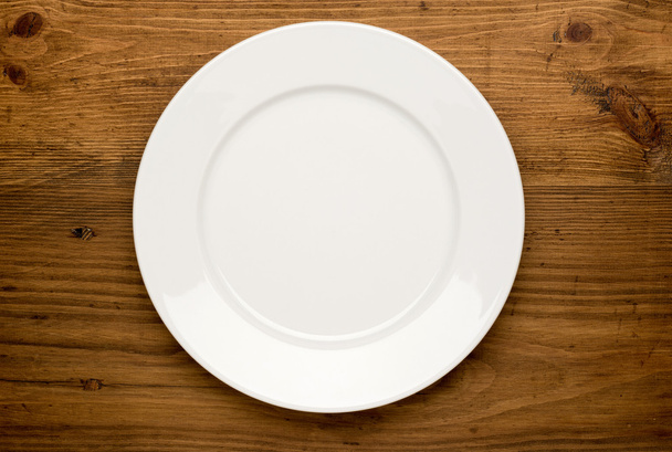 Empty white plate on wooden table - Fotoğraf, Görsel