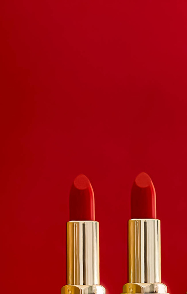 Червона помада в золотих трубках на кольоровому фоні, розкішний макіяж і косметика для концепції дизайну бренду краси
 - Фото, зображення