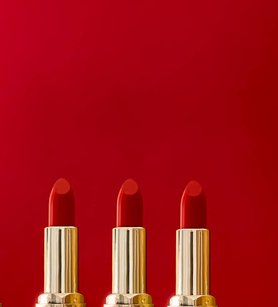 Red lipstick in golden tubes on colour background, luxury make-up and cosmetics for beauty brand product design concept - Photo, Image