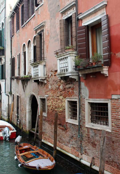 Velencei csatorna. Színes homlokzatok, hajók, nyugodt folyóvíz. Olaszország gyönyörű építészete. Legromantikusabb úti célok.  - Fotó, kép