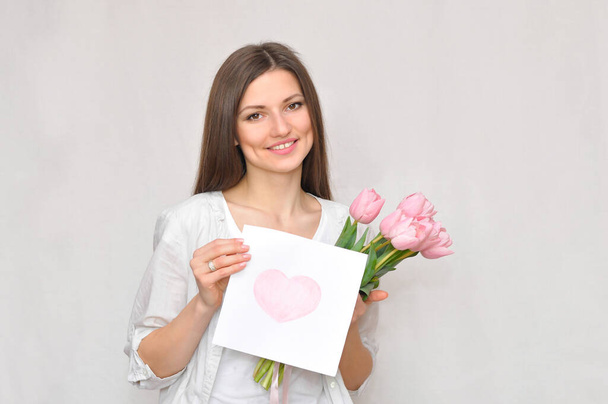 Beautiful woman mommy smiling with flowers and gift.Mother's day holiday. - Photo, Image