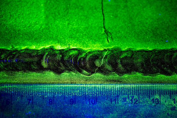 Crack steel butt weld carbon background green contrast of magnetic filed fluorescent test - Fotó, kép
