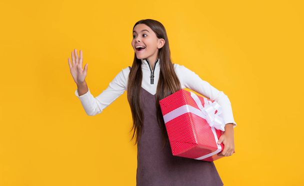 surprised kid with present box on yellow background. - Foto, Imagem