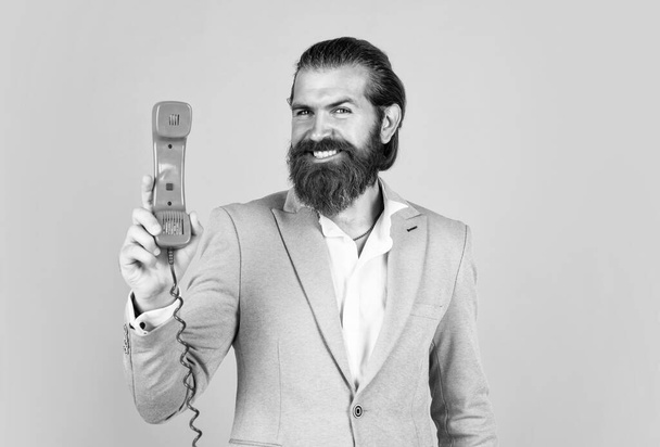 handsome caucasian businessman with trendy hairstyle in jacket speak on vintage phone, digital age. - Photo, Image
