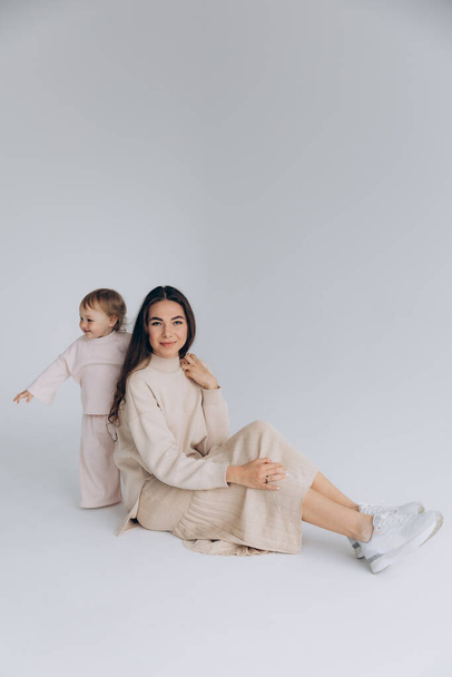 29.04.22 Kyiv, Ukraine: Portrait of two beautiful attractive cute girls, attractive mom and her little stylish daughter who support upbringing, isolated on a white background - Foto, Imagem