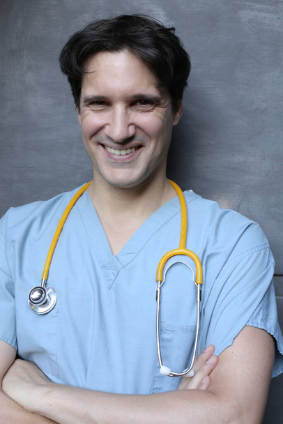 muotokuva komea nuori lääkäri stetoskooppi harmaa seinä tausta - Valokuva, kuva