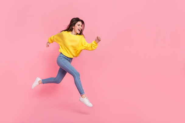 Full size profile side photo of young excited lady hurry movement jump look empty space isolated over pink color background. - Foto, Imagem