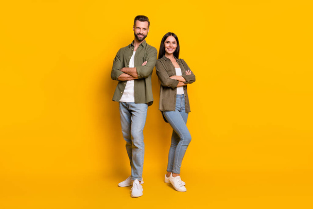 Full body photo of young confident man woman folded hands team colleagues isolated over yellow color background. - Фото, изображение