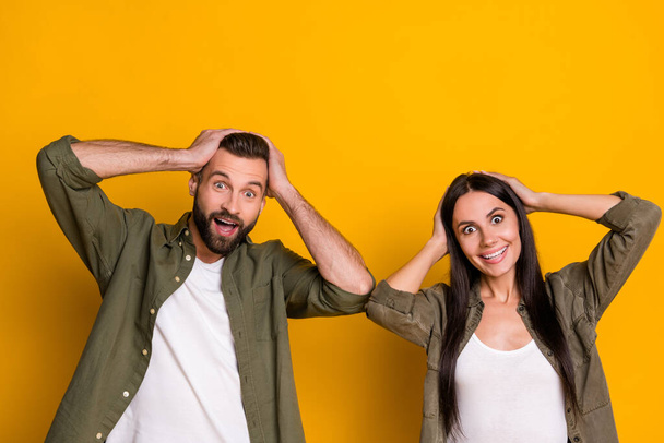 Photo of young spouses hands touch head reaction omg wow news unbelievable isolated over yellow color background. - Fotoğraf, Görsel