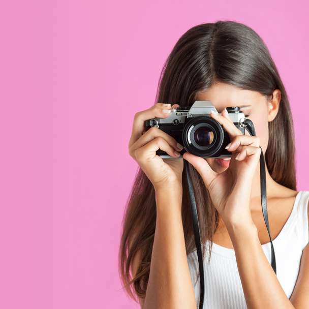 Woman with camera close up against pink background. - Foto, immagini