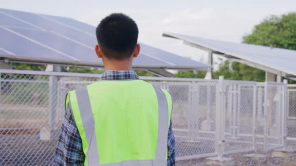 Engineer lopen rond zonnecellen station voor het controleren van systeem en onderhoud zonnepaneel, Groene energie en duurzaam milieu concept. - Video