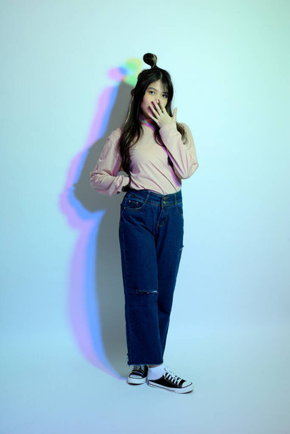 The cute young Asian girl with casual clothes posing under the gel color lightning in studio. - Φωτογραφία, εικόνα