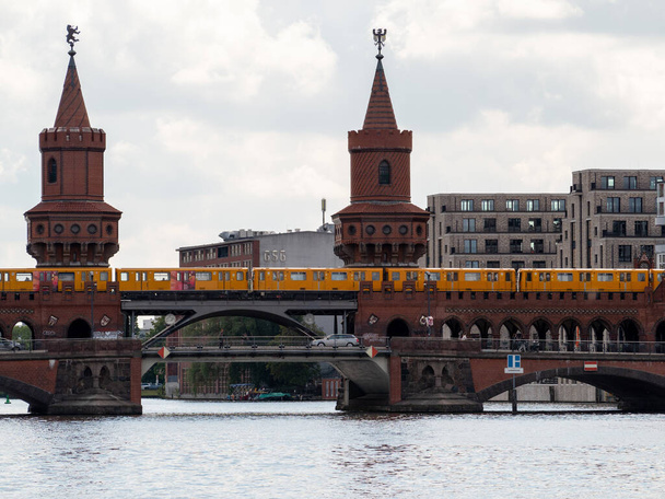 Желтый поезд в Берлине. Поезд на вокзал. Желтый поезд на мосту Обербаум в Берлине, Германия - Фото, изображение