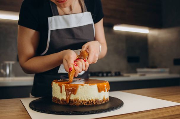 makeiset kaataa karamelli kakku keittiössä - Valokuva, kuva