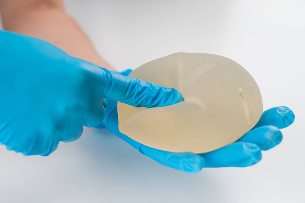 A plastic surgeon shows a breast silicone implant - Fotó, kép