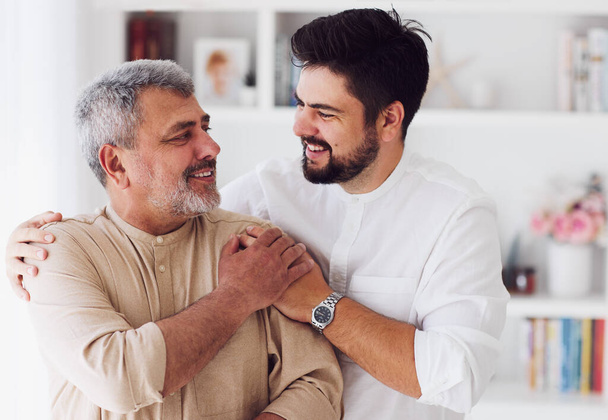 portrait of cheerful laughing adult father and son at home - Фото, зображення
