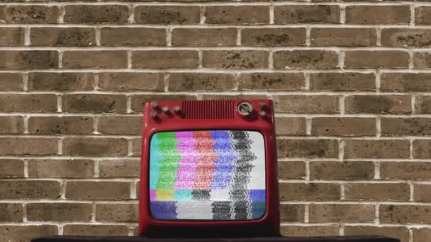 Velha televisão acendendo tela verde contra uma parede de tijolo.   - Filmagem, Vídeo