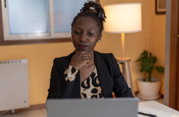 Çevrimiçi bir toplantıda genç siyahi bir kadının portresi. Üzerinde hayvan desenli bir bluz ve siyah bir spor ceket var. - Fotoğraf, Görsel