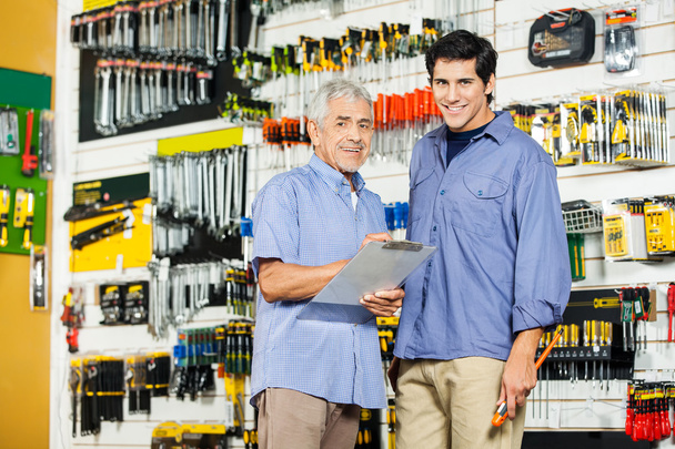 Father And Son With Clipboard In Hardware Store - Foto, afbeelding