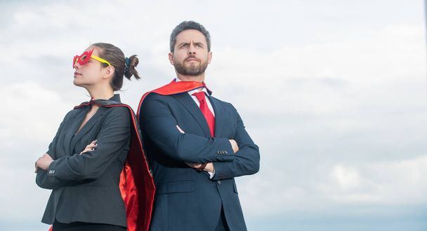 空を背景にスーパーヒーロースーツのビジネスカップル。動機. - 写真・画像