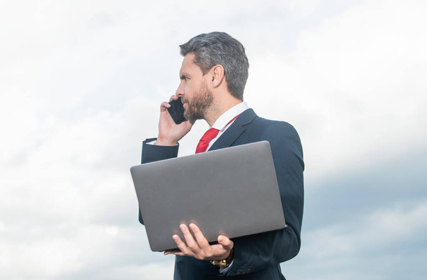 businessman in suit speak on phone and hold laptop. - Photo, Image