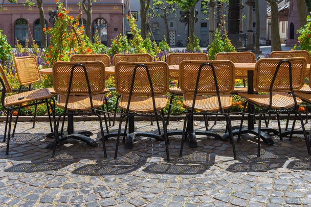 székek és asztalok egy kávézó előtt egy városban nyáron - Fotó, kép