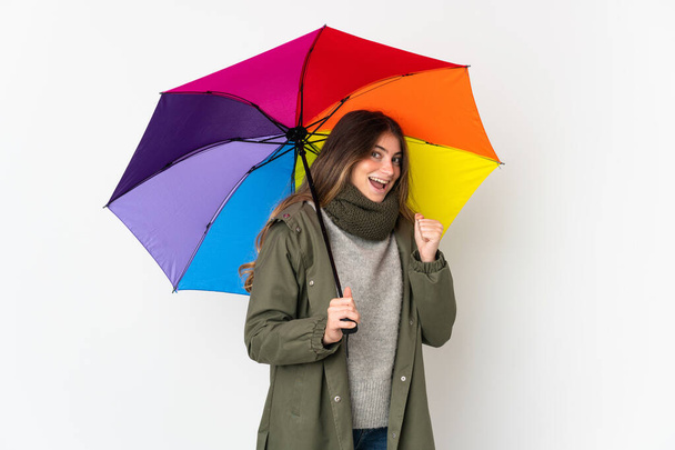Beyaz arka planda şemsiyesi olan beyaz bir kadın zaferi kutluyor. - Fotoğraf, Görsel