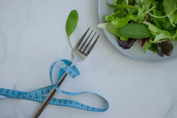 Листья салата измеряют ленту на тарелке - Фото, изображение