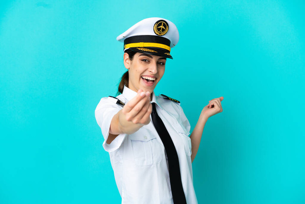 pilot samolot kaukaski kobieta odizolowany na niebieski tło co pieniądze gest - Zdjęcie, obraz