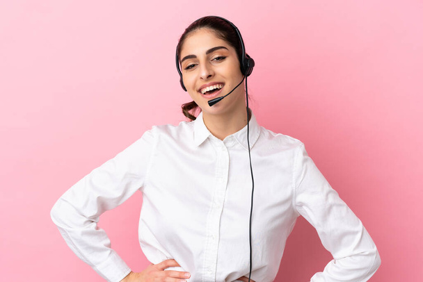 Young telemarketer over isolated background posing with arms at hip and smiling - Foto, Bild