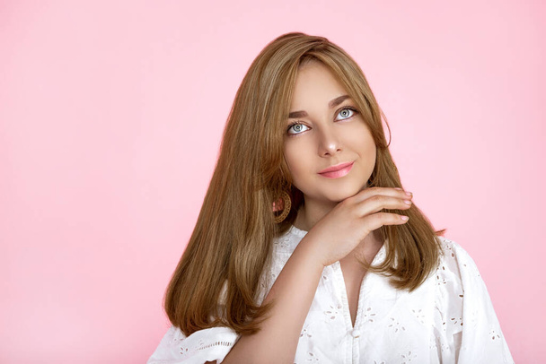 Portrait of a beautiful natural and smiling girl on a pink background. Beautiful young girl with perfect face and beautiful hair is posing in studio. Beauty, makeup, hair. Perfect face. - Foto, Bild