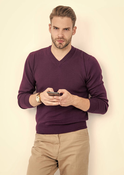 Όμορφος άνθρωπος σε casual στυλ μήνυμα κειμένου στο κινητό τηλέφωνο απομονώνονται σε λευκό, sms. - Φωτογραφία, εικόνα