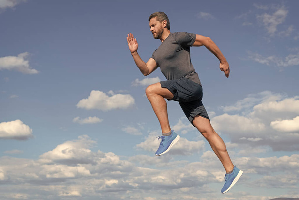 energický muž sportovec sprint s svalnatým tělem běh ve sportovním oblečení venku na obloze pozadí, motivace. - Fotografie, Obrázek