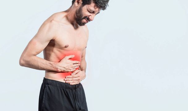 shirtless man with stomach ache, stomach problems concept, man with digestive problems, person with stomach ache, sore man holding his stomach isolated - Fotoğraf, Görsel