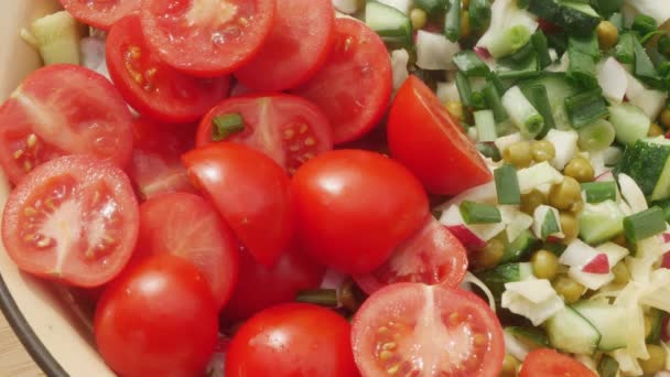 hand zet gesneden tomaten en zwart brood in de lente salade. - Video