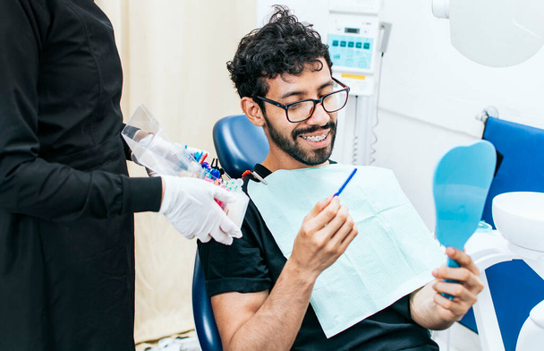 Potilas, jolla hammaslääkäri valitsee hammasraudat, Hammaslääkäri, jolla potilas valitsee metalliraudat, Potilas, jolla hammaslääkäri valitsee kuminauhan - Valokuva, kuva