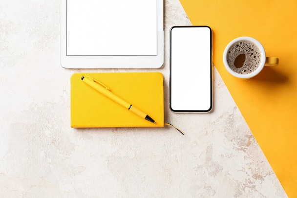 Mobiltelefon, tabletta számítógép, csésze kávé, notebook és toll színes háttér - Fotó, kép