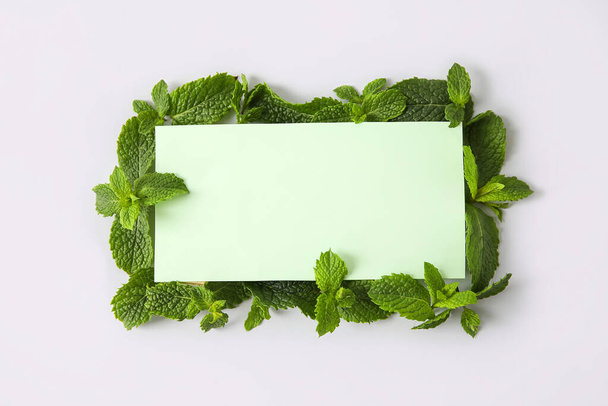 Frame made of mint leaves and blank card on white background - Photo, Image