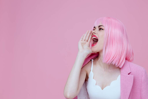Pozitív fiatal nő gesztusok a kezét egy rózsaszín kabát Stúdió Modell változatlan. Kiváló minőségű fénykép - Fotó, kép