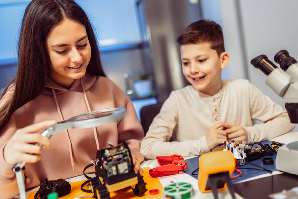 Shot of young brother and sister enjoying spending time together building a robot  - Foto, Bild