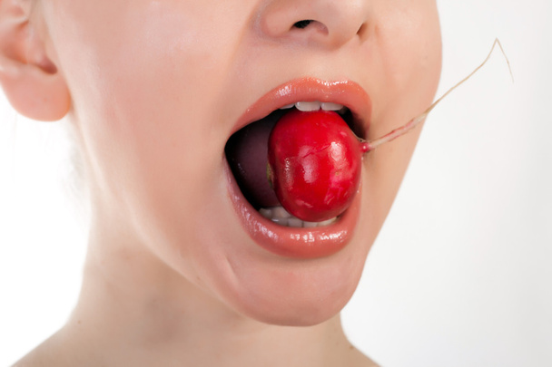 Jolie mannequin tenant du radis dans sa bouche
 - Photo, image